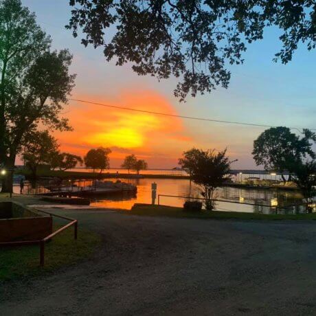 A tranquil sunset over the marina, featuring docked boats and the glowing lake waters—capturing the serene beauty of Lake Tawakoni at 429 Resort & Marina in Quinlan, TX.