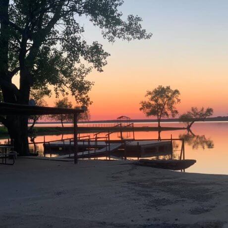 A tranquil sunset over the marina, featuring docked boats and the glowing lake waters—capturing the serene beauty of Lake Tawakoni at 429 Resort & Marina in Quinlan, TX.