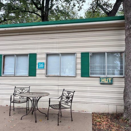 A scenic view of a cabin surrounded by lush trees, with Lake Tawakoni in the background, showcasing the peaceful lakeside atmosphere at 429 Resort & Marina in Quinlan, TX.